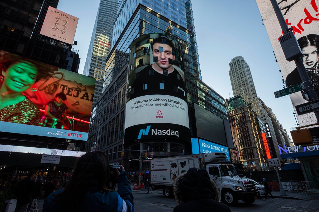 De oprichter van Airbnb op groot scherm op Times Square in New York voor het beursdebuut van Airbnb.